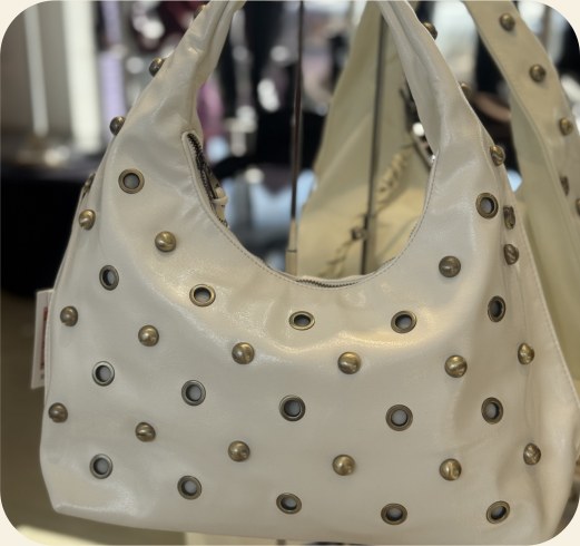 Bolsa hobo com ilhoses e tachas