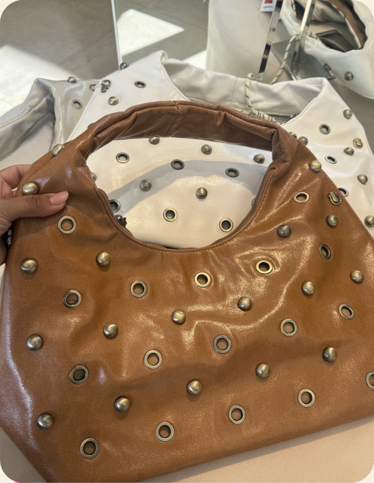 Bolsa hobo com ilhoses e tachas
